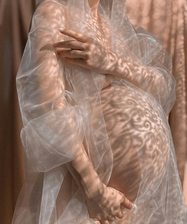 femme enceinte tenant des fleurs