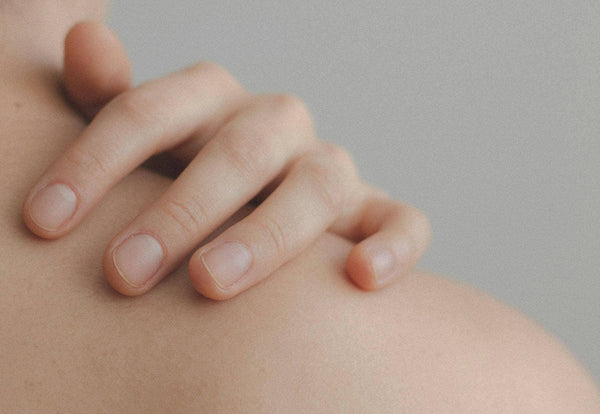 femme touchant son épaule