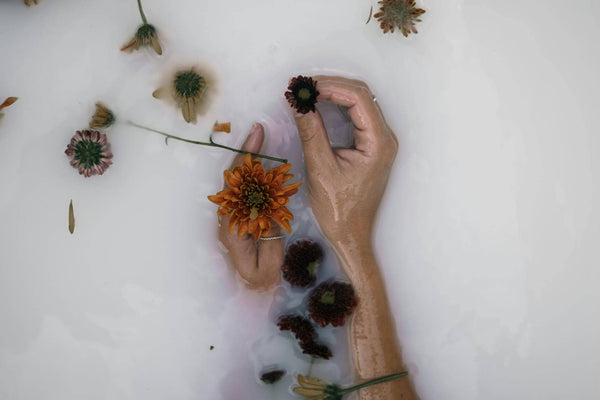 fleurs et mains dans un bain