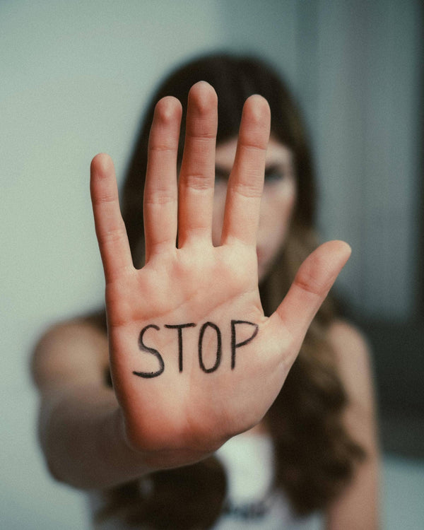 main d'une femme avec écrit stop