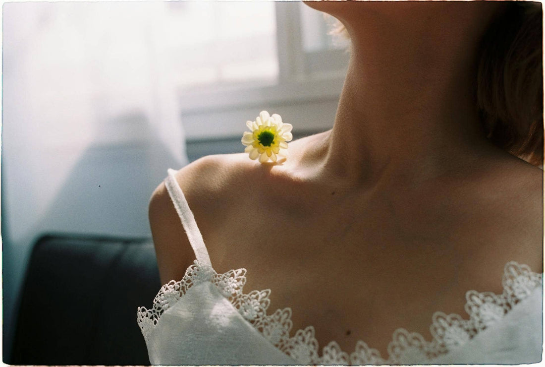 femme sensuelle avec une fleur sur l'épaule