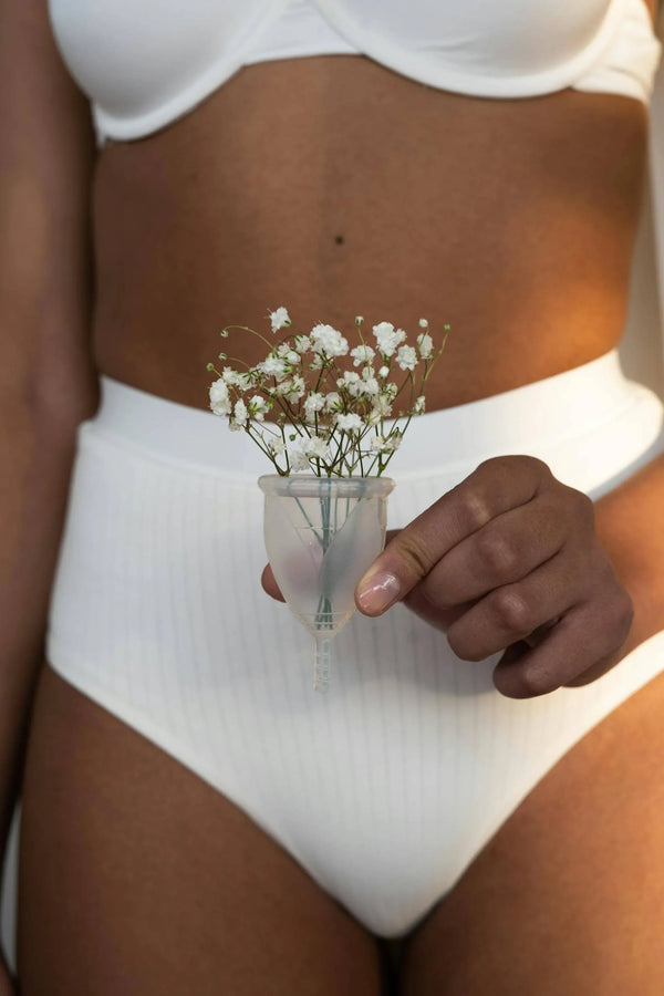 femme tenant une cup menstruelle