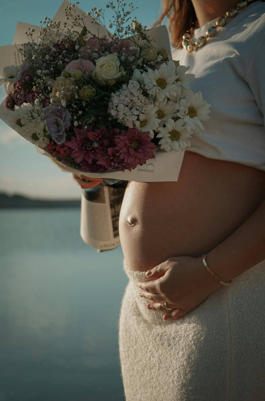 femme enceinte tenant des fleurs